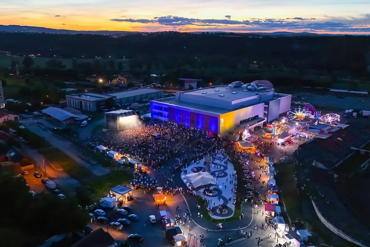 Vedere aeriană la amurg asupra unei clădiri iluminate și a unui spațiu de eveniment